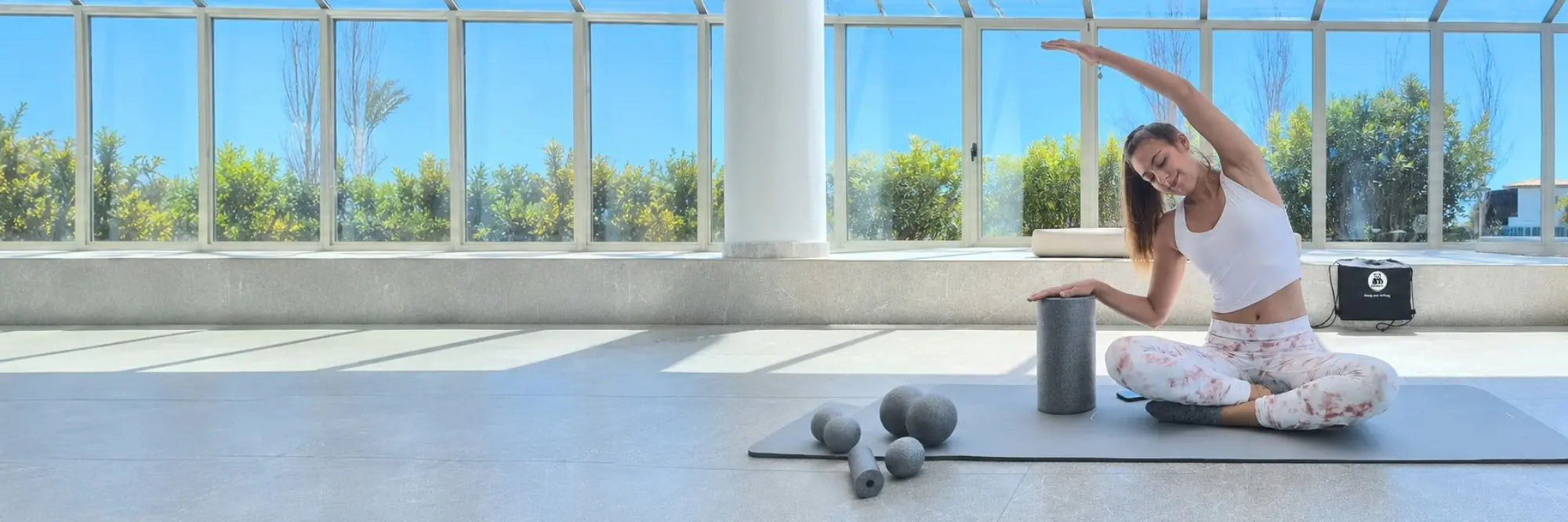 Faszientraining mit PandaFit Faszienrollen-Set – Frau bei Side-Stretch mit Faszienrolle, Duobällen und Faszienball auf Yogamatte
